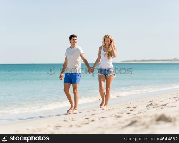 Romantic young couple on the beach. Romantic young couple on the beach walking along the shore