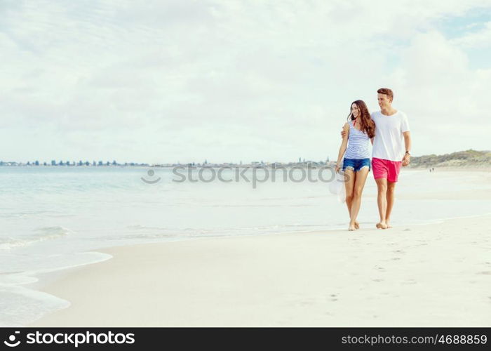 Romantic young couple on the beach. Romantic young couple on the beach walking along the shore