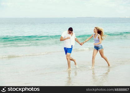 Romantic young couple on the beach. Romantic young couple on the beach running along the shore