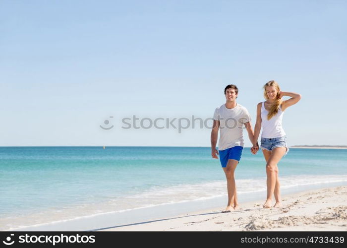 Romantic young couple on the beach. Romantic young couple on the beach walking along the shore