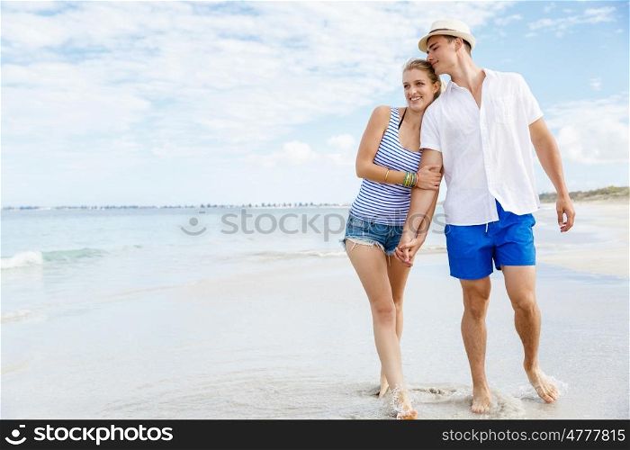 Romantic young couple on the beach. Romantic young couple on the beach waloking along the shore