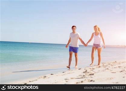 Romantic young couple on the beach. Romantic young couple on the beach walking along the shore