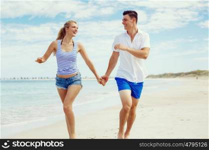 Romantic young couple on the beach. Romantic young couple on the beach running along the shore