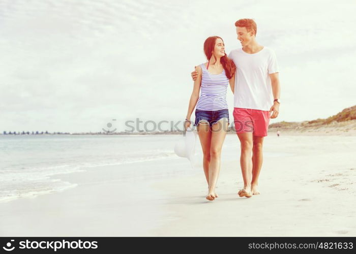 Romantic young couple on the beach. Romantic young couple on the beach walking along the shore