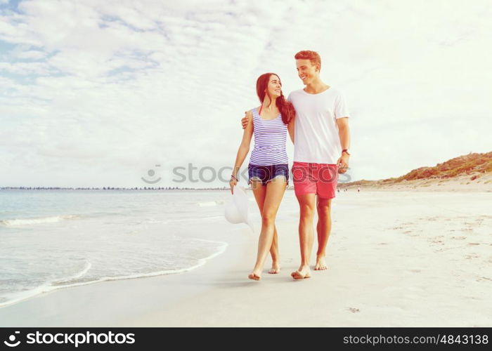 Romantic young couple on the beach. Romantic young couple on the beach walking along the shore