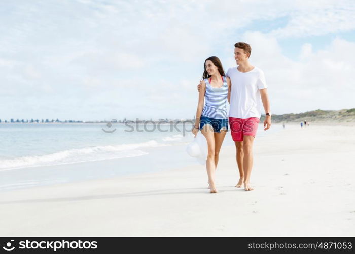 Romantic young couple on the beach. Romantic young couple on the beach waloking along the shore