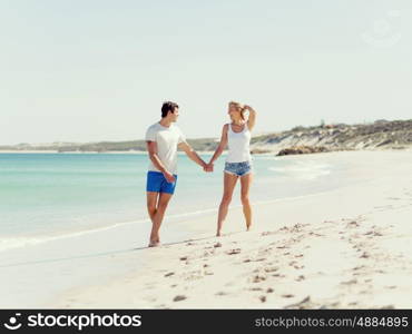 Romantic young couple on the beach. Romantic young couple on the beach walking along the shore