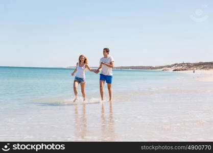 Romantic young couple on the beach. Romantic young couple on the beach walking along the shore