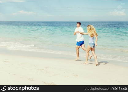 Romantic young couple on the beach. Romantic young couple on the beach running along the shore
