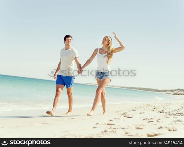 Romantic young couple on the beach. Romantic young couple on the beach walking along the shore