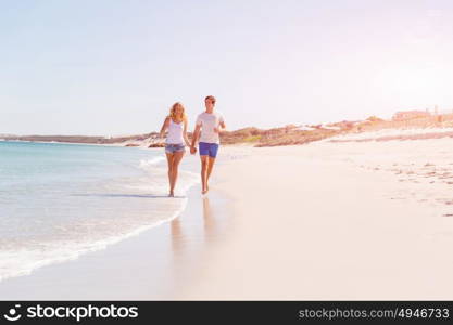 Romantic young couple on the beach. Romantic young couple on the beach walking along the shore