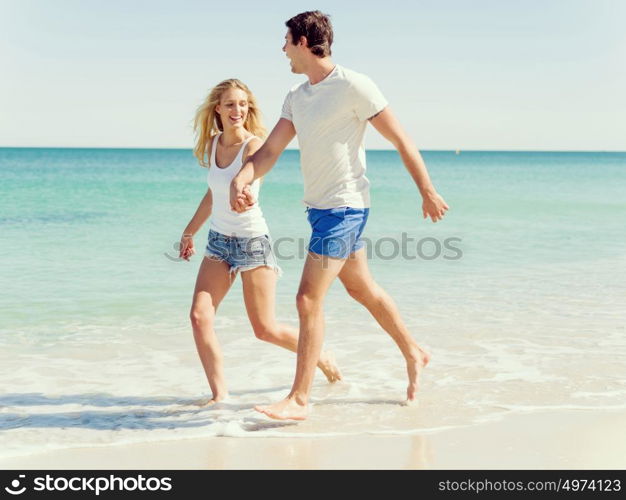 Romantic young couple on the beach. Romantic young couple on the beach walking along the shore