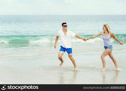 Romantic young couple on the beach. Romantic young couple on the beach running along the shore