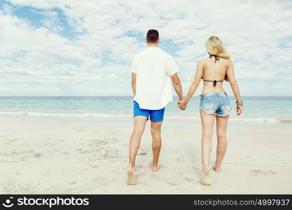 Romantic young couple on the beach. Romantic young couple on the beach walking along the shore