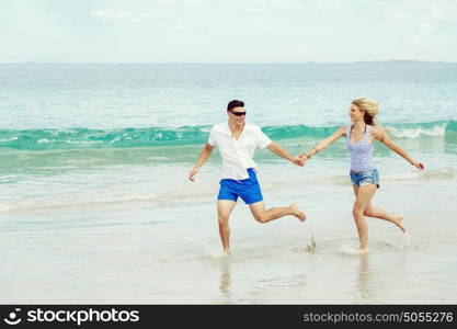 Romantic young couple on the beach. Romantic young couple on the beach running along the shore