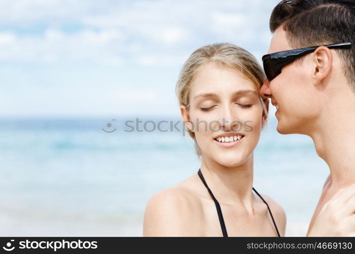 Romantic young couple on the beach. Romantic young couple standing next to each other on the beach