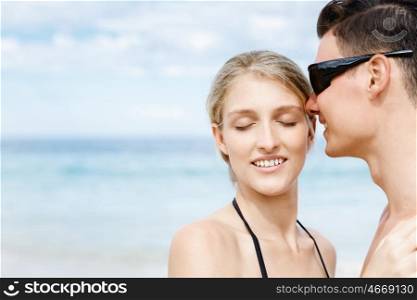 Romantic young couple on the beach. Romantic young couple standing next to each other on the beach