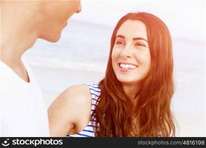 Romantic young couple on the beach. Romantic young couple standing on the beach looking at each other