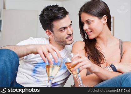Romantic young couple sharing glass of wine