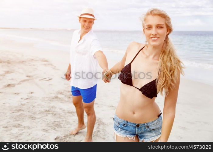 Romantic young couple sitting on the beach. Romantic young couple sitting on the beach looking at each other