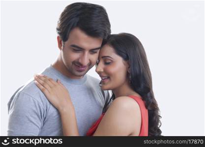 Romantic young couple smiling against white background