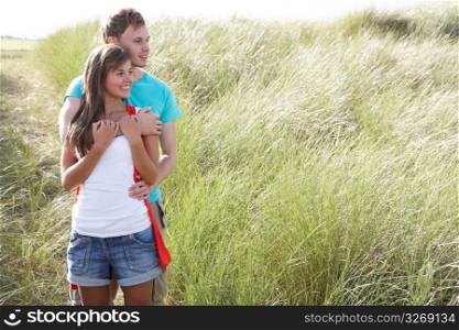 Romantic Young Couple Standing Amongst Dunes