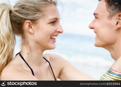 Romantic young couple standing on the beach. Romantic young couple standing on the beach looking at each other