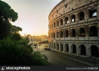 Rome Colosseum at morning sunrise and crowded street of Rome , Italy . The Colosseum was built in the time of Ancient Rome in the city center. It is one of most popular tourist attractions in Italy .
