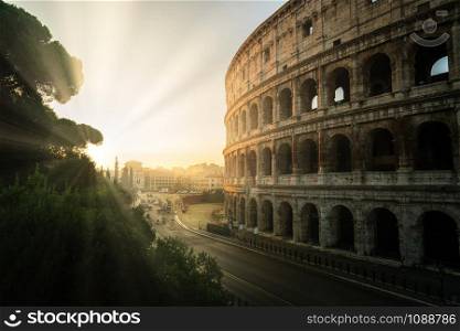 Rome Colosseum at morning sunrise and crowded street of Rome , Italy . The Colosseum was built in the time of Ancient Rome in the city center. It is one of most popular tourist attractions in Italy .