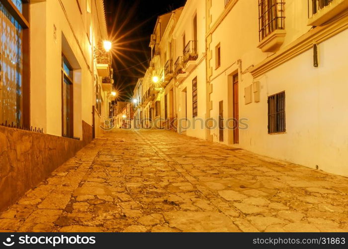 Ronda. Village street at night.. Traditional narrow village street with glowing lanterns in Ronda. Spain. Andalusia.