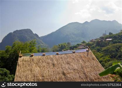 Roof hut made ??of dry grass. With a mountain background at northern thailand.