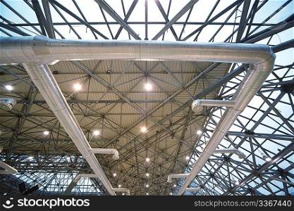 Roof of building from inside: extinguishing system and lighting. Frame of steel structures.