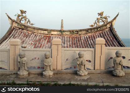 Roof of temple and buddhas in Chongwu, China