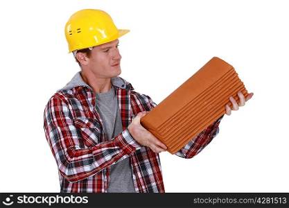 Roofer holding pile of tiles