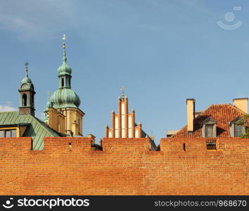 Roofs of beautiful old buildings behind a high fortification wall in Old Town (Stare Miasto) of Warsaw