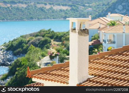 Roofs of Greek houses in suburbs of seaside tourist town. Mediterranean architecture, traveling in Europe for vacations.. Roof of greek house in suburbs
