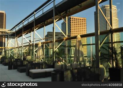 Rooftop seating area with catwalk and skyscraper sunset view