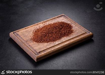 Rooibos tea in a white bowl on a black background. Flat lay, top view, copy space. Rooibos tea on a black background. Flat lay, copy space