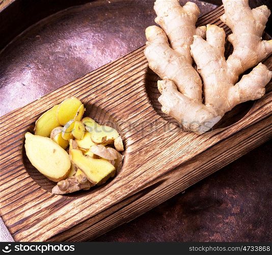 Root of medicinal ginger. wooden mortar with the root of medicinal ginger