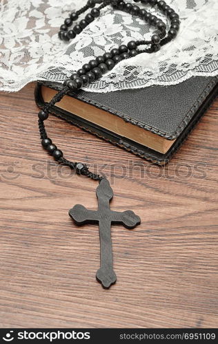 Rosary beads and a bible with a white chapel veil