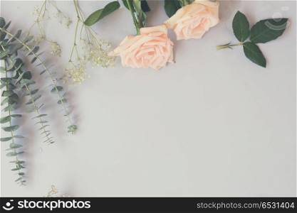 Rose flowers and green leaves on blue table from above with copy space, retro toned. fresh rose flowers. fresh rose flowers