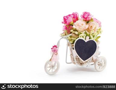 Rose flowers in bicycle basket with heart clothes pin on white background