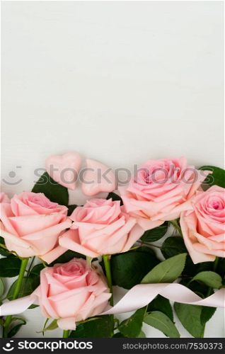Rose fresh flowers border on table from above with gift boxes and copy space, flat lay scene. fresh rose flowers
