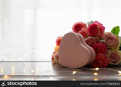 Rose fresh flowers bouquet on gray table by the window with pink heart gift box. fresh rose flowers on gray