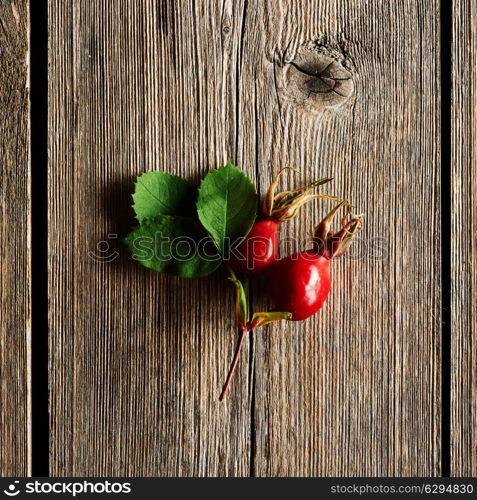 Rose hip over old wooden background with copy space