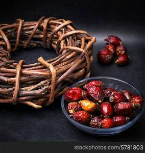 rose in white bowl on background licorice root bound in coil. healing herbs