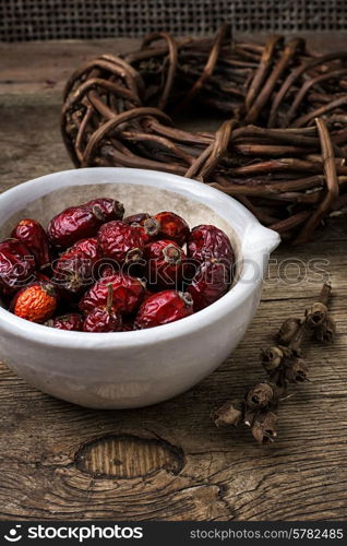 rose in white bowl on background licorice root bound in coil.Selective focus. healing herbs