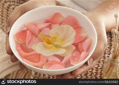 Rose petals and orchid in a bowl with reed diffuser