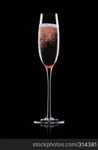 Rose pink champagne glass with bubbles on black background with reflection