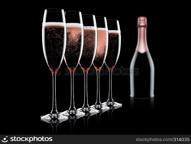 Rose pink champagne glasses and bottle on black background with reflection
